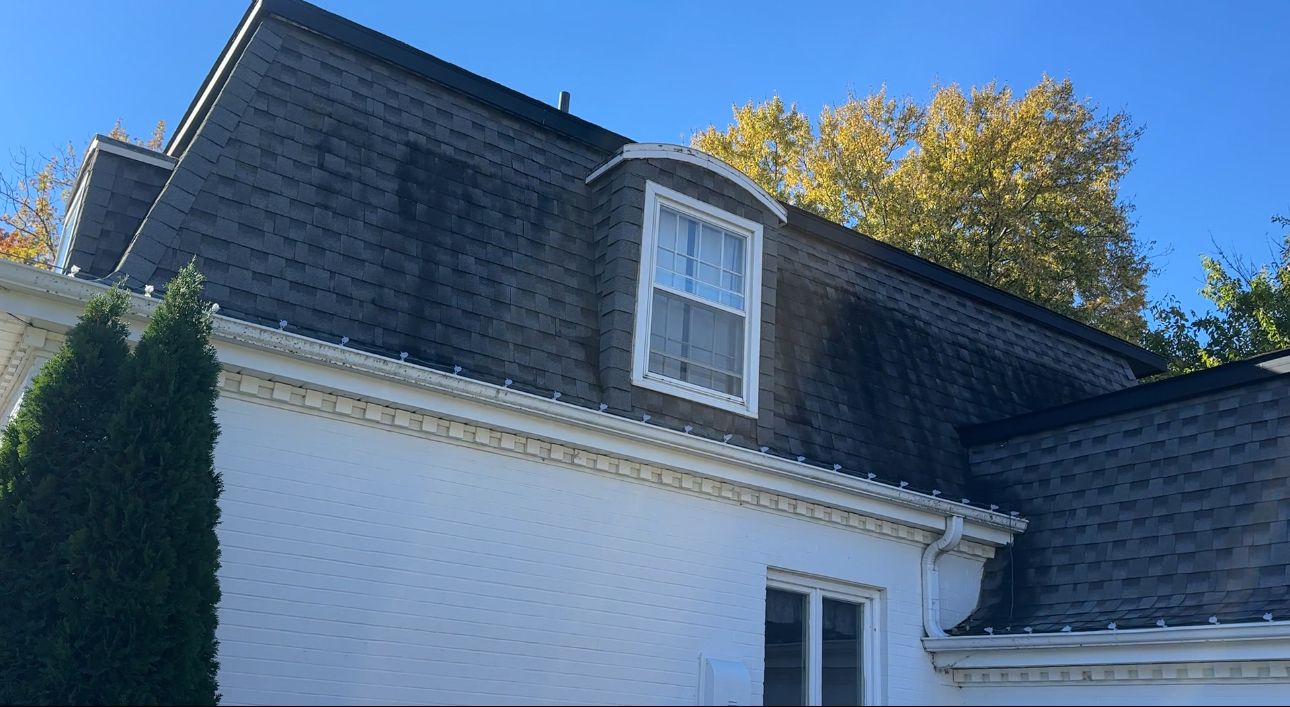 Black roof streaks around a dormer before roof cleaning, El Dorado, KS