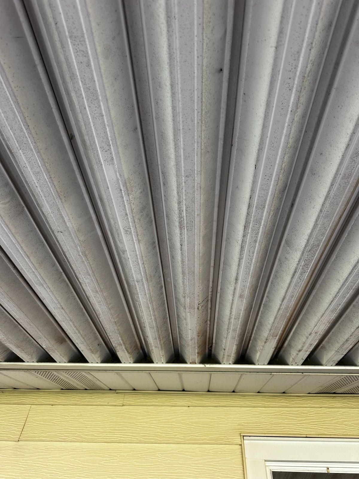 Dirty metal patio cover before cleaning