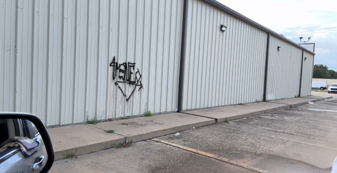 Graffiti tag on a white metal commercial building in Wichita, KS