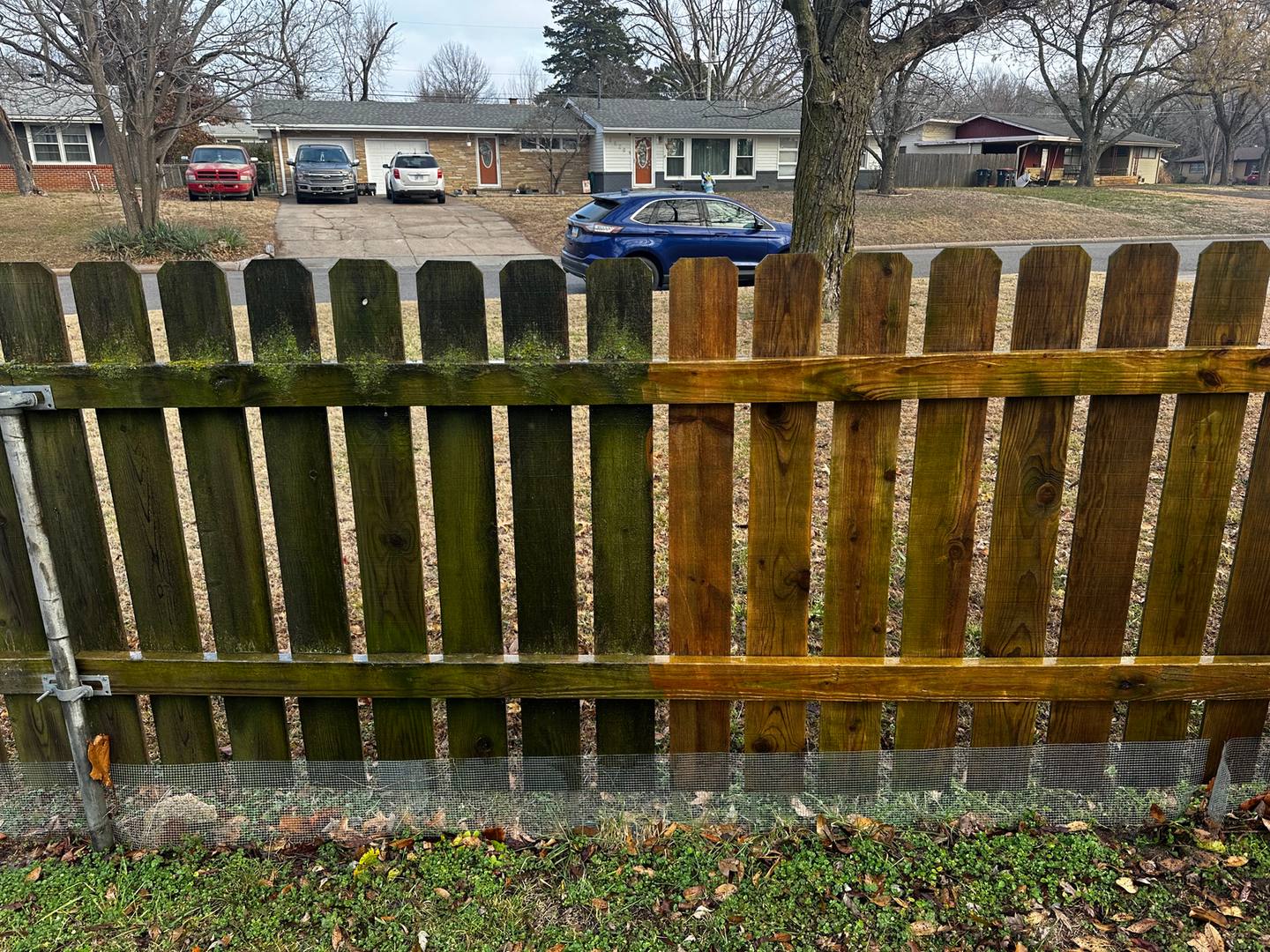 Wood fence with dirty and cleaned sections side by side