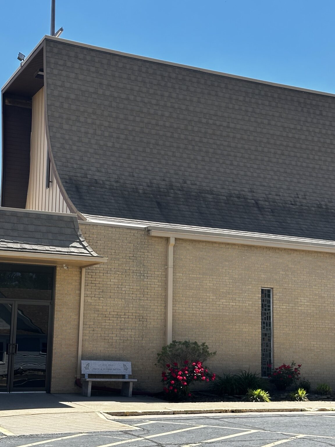 Heavy black algae streaks above the church entrance before roof cleaning