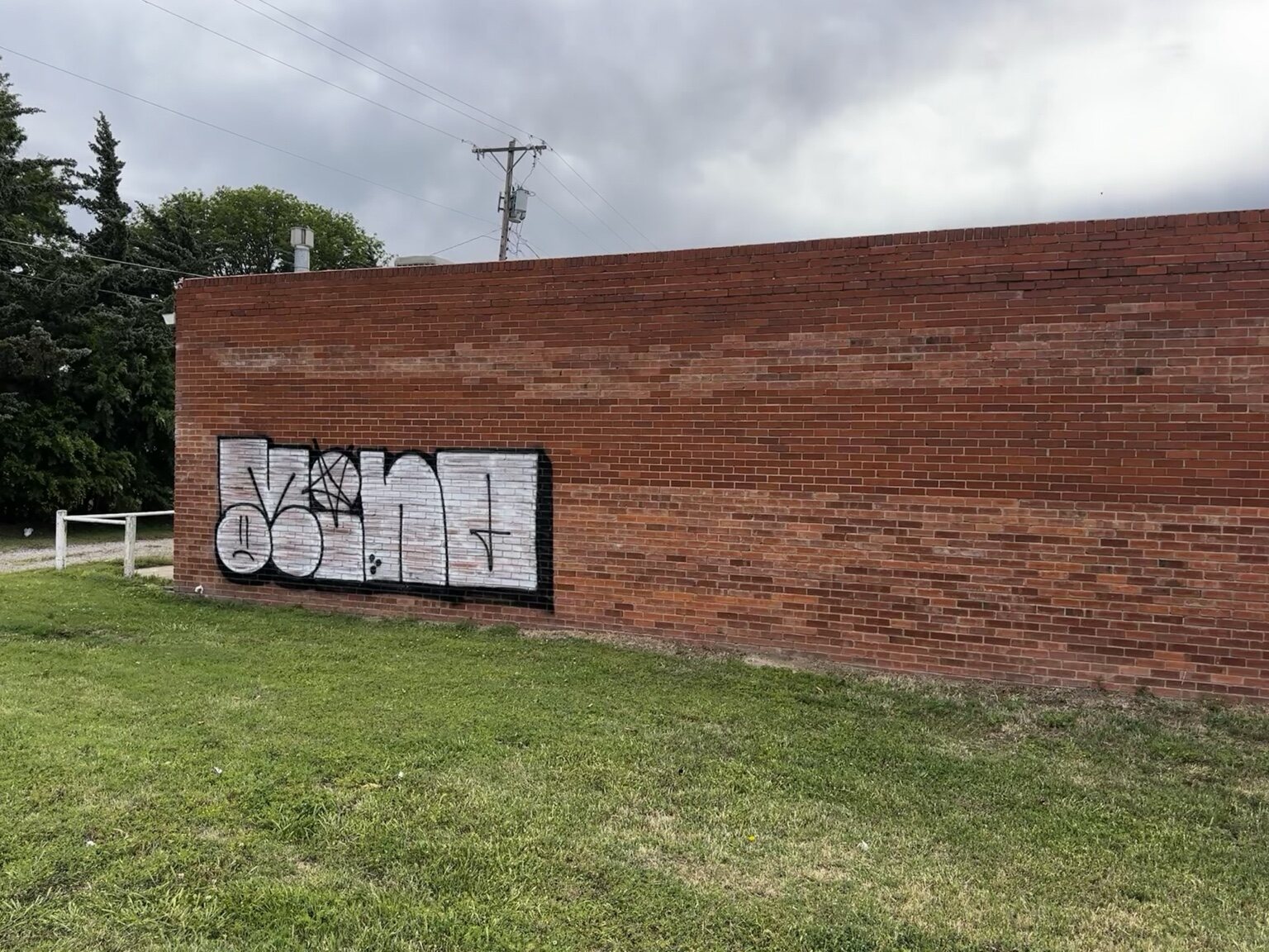 Large graffiti tag covering a brick commercial wall in Wichita